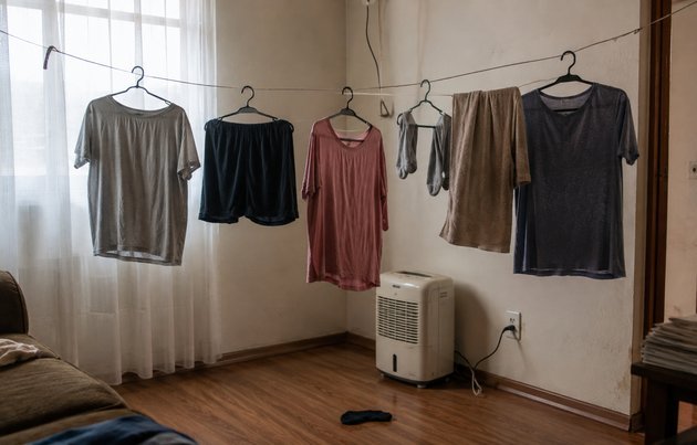 Roupa secando dentro de apartamento pequeno sem varanda