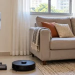 Aspirador vertical e robô aspirador lado a lado na sala de uma casa pequena