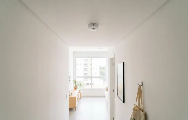 Sensor de presença instalado no teto de corredor de apartamento pequeno